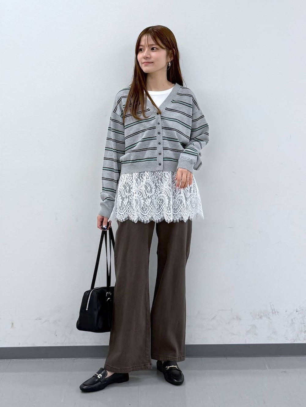 ブラック系のローファー、ブラウン系のデニムパンツ、ホワイト系のタンクトップを着用したレディースの春コーディネートの3枚目の写真