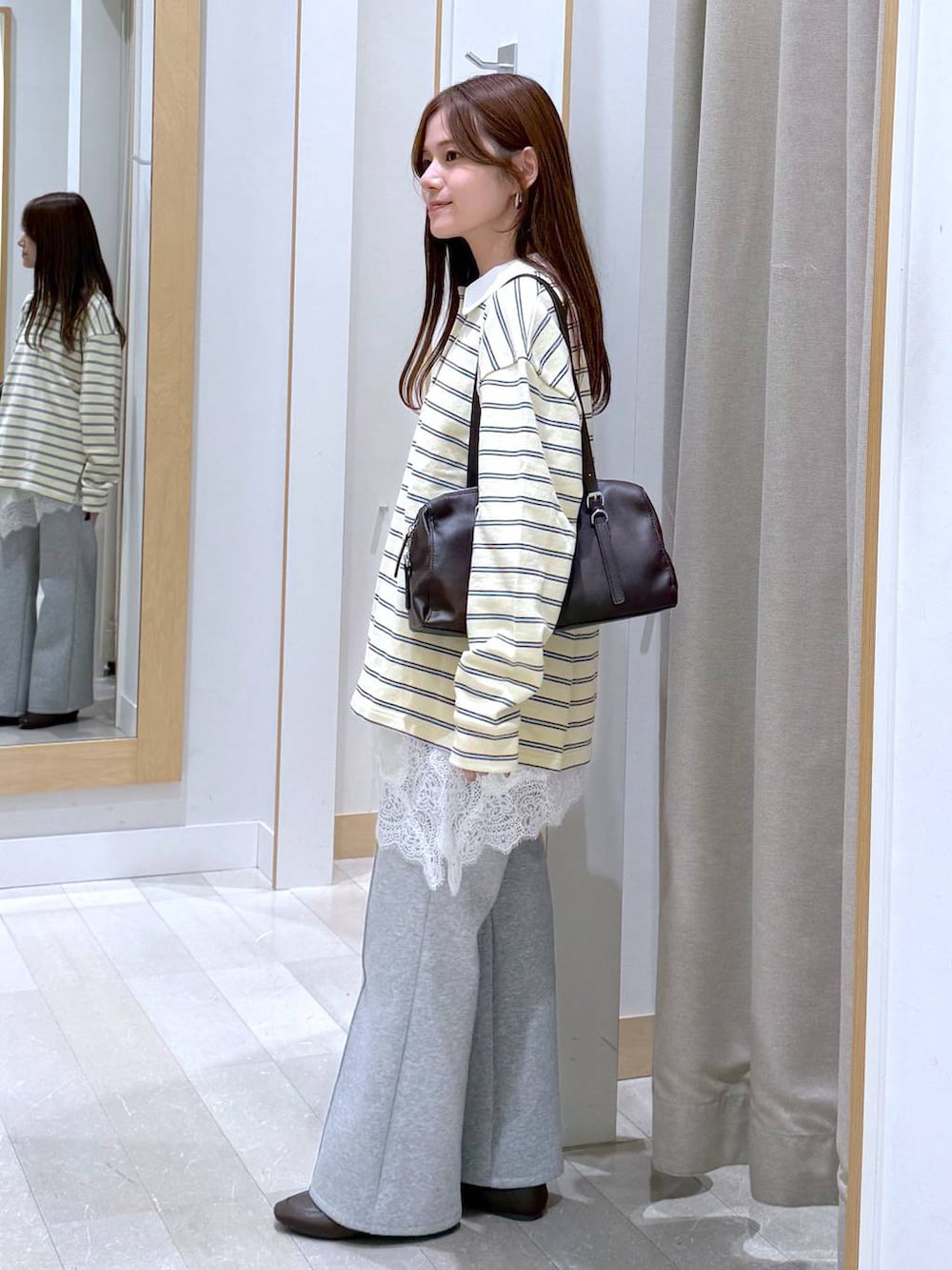 グレー系のスウェットパンツ、イエロー系のスウェット、ブラウン系のショルダーバッグを着用したレディースの春コーディネートの2枚目の写真