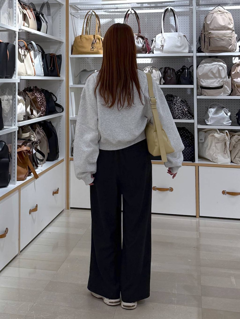 ブラック系のその他パンツ、イエロー系のショルダーバッグ、シルバー系のネックレスを着用したレディースの冬コーディネートの3枚目の写真