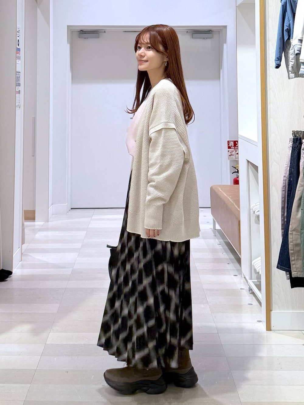 ベージュ系のカーディガン/ボレロ、ブラウン系のブーツ、ピンク系のニット/セーターを着用したレディースの冬コーディネートの2枚目の写真