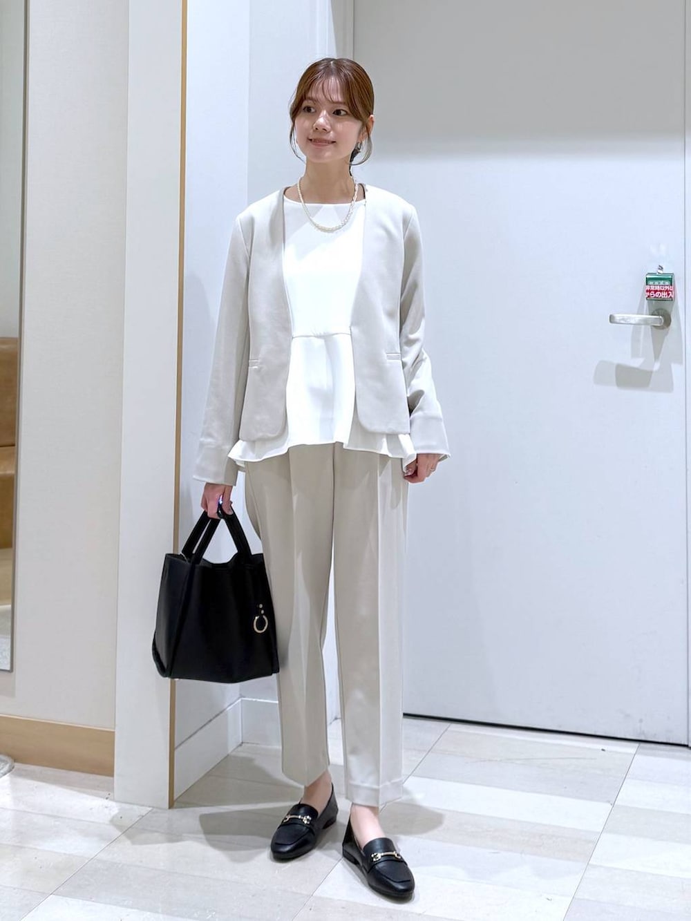 ブラック系のローファー、ブラック系のトートバッグ、ベージュ系のセットアップを着用したレディースの冬コーディネートの4枚目の写真