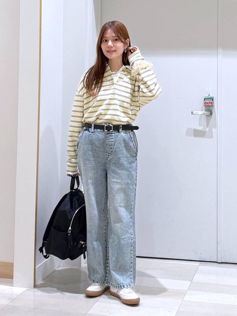 ホワイト系のスニーカー、ブラック系のバックパック/リュック、ブルー系のデニムパンツを着用したレディースの春コーディネートの5枚目の写真