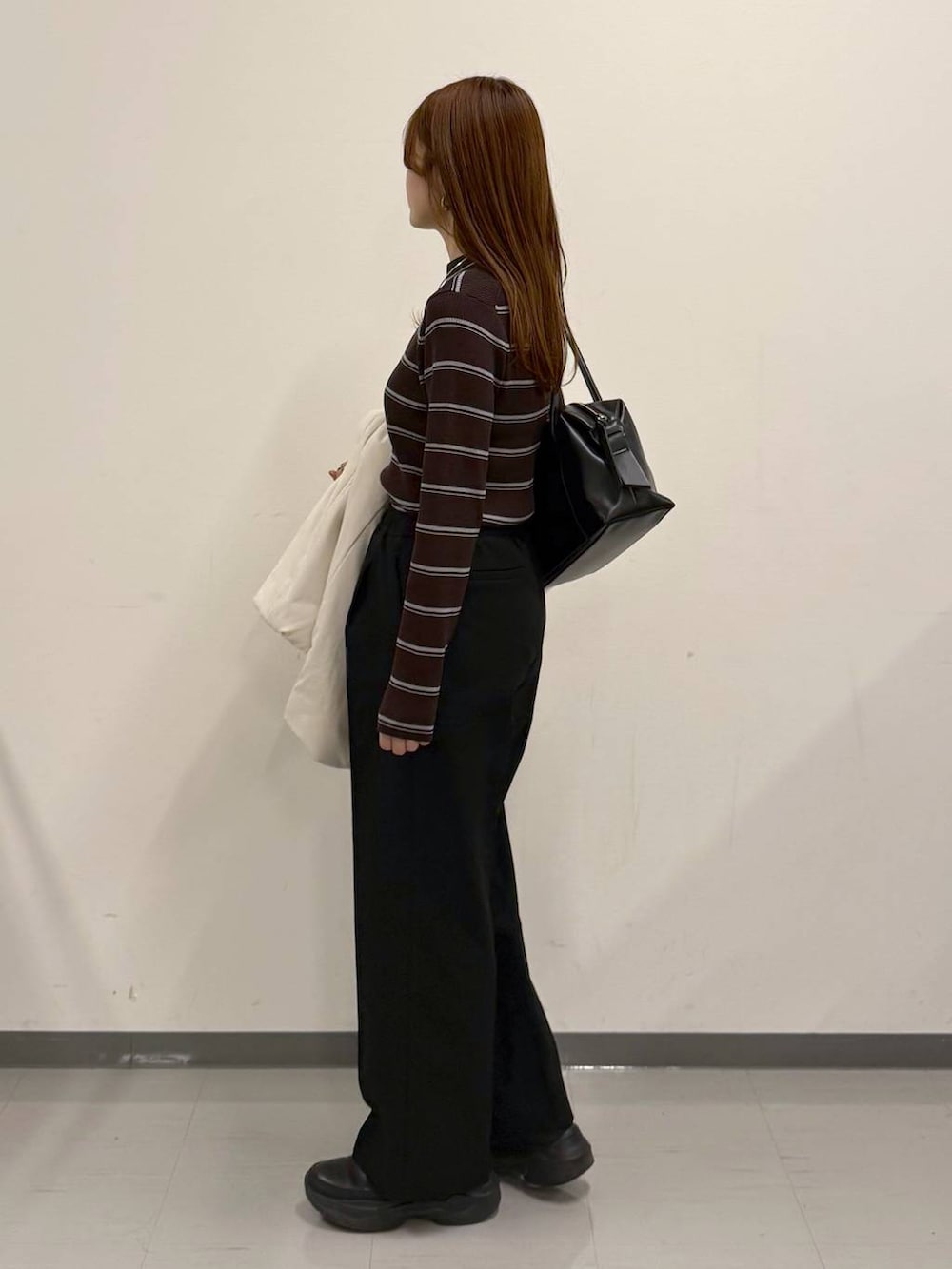 ブラック系のボストンバッグ、ブラック系のその他パンツ、ブラック系のブーツを着用したレディースの冬コーディネートの2枚目の写真