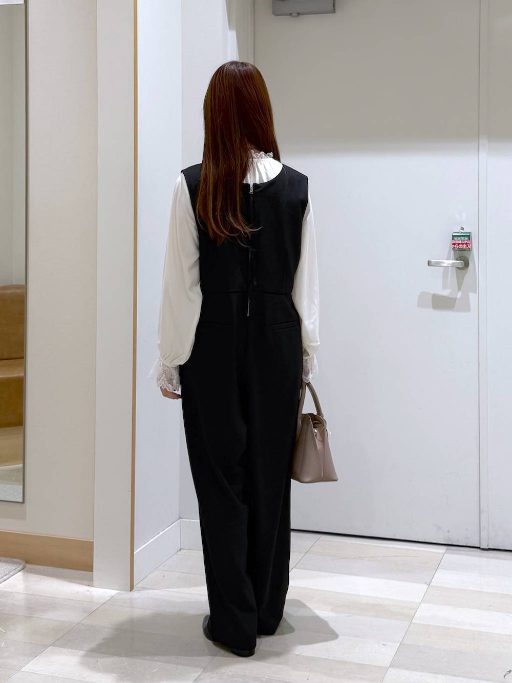 ベージュ系のショルダーバッグ、ブラック系のパンプス、ホワイト系のシャツ/ブラウスを着用したレディースの冬コーディネートの3枚目の写真