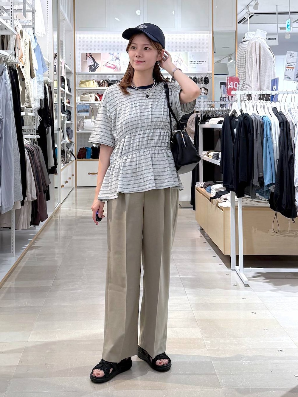 ベージュ系のその他パンツ、ブラック系のサンダル、グレー系のTシャツ/カットソーを着用したレディースの夏コーディネートの4枚目の写真