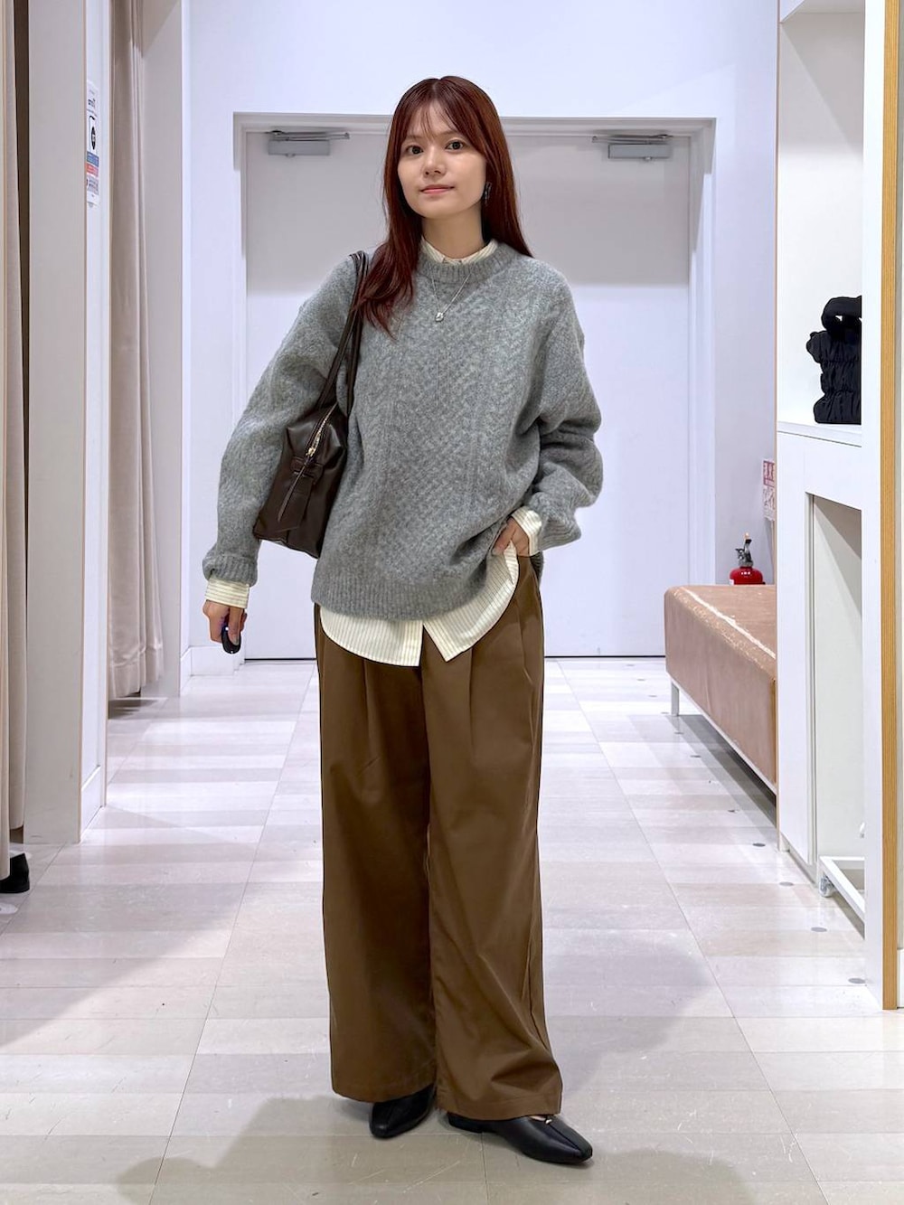 ブラック系のパンプス、レッド系のボストンバッグ、グレー系のその他パンツを着用したレディースの秋コーディネートの6枚目の写真