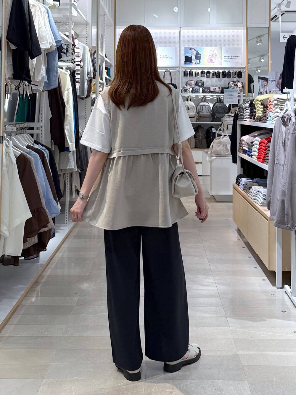ベージュ系のショルダーバッグ、ベージュ系のベスト、ホワイト系のTシャツ/カットソーを着用したレディースの春コーディネートの3枚目の写真