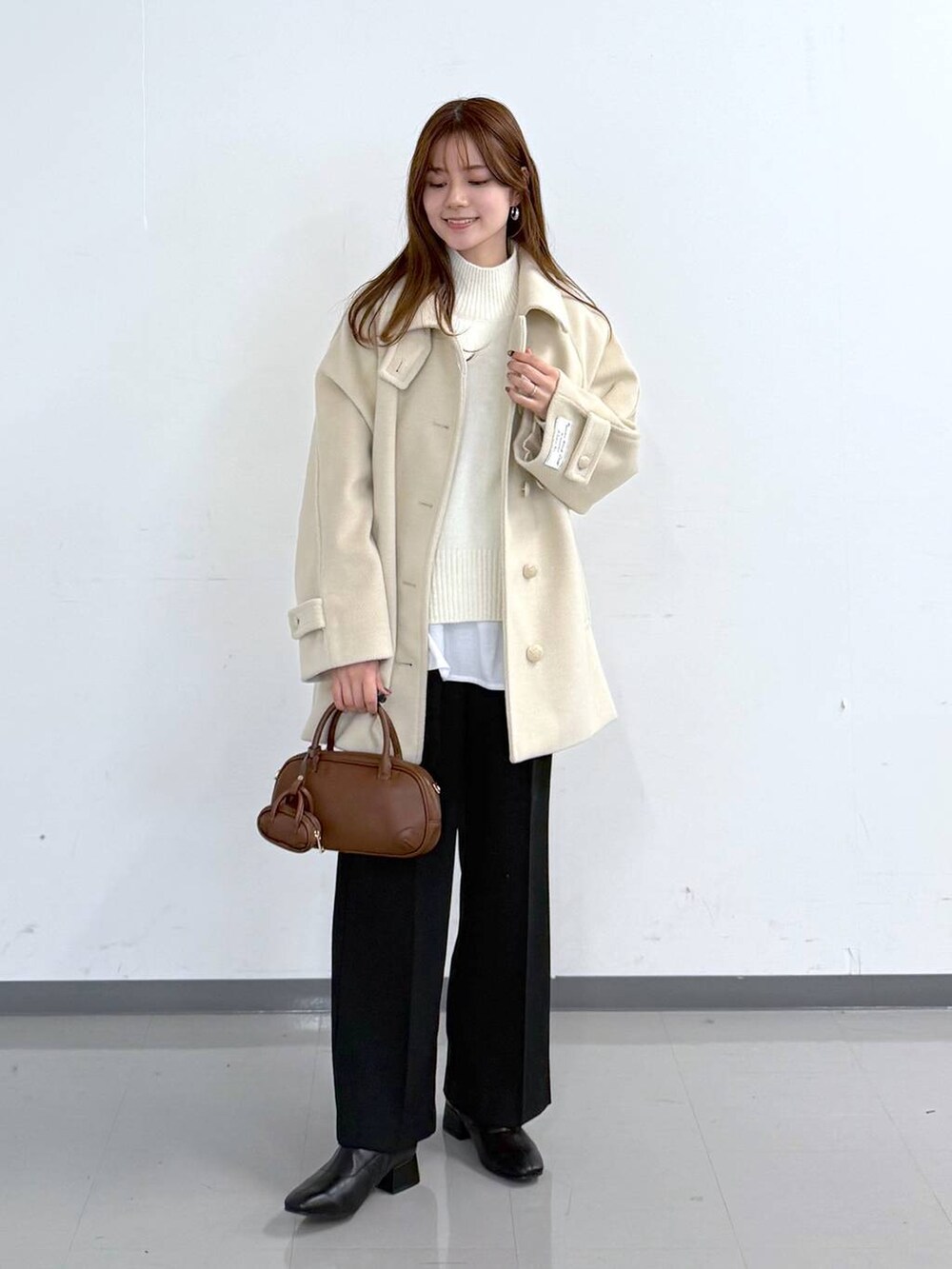 ホワイト系のニット/セーター、ブラック系のその他パンツ、ホワイト系のTシャツ/カットソーを着用したレディースの冬コーディネートの4枚目の写真