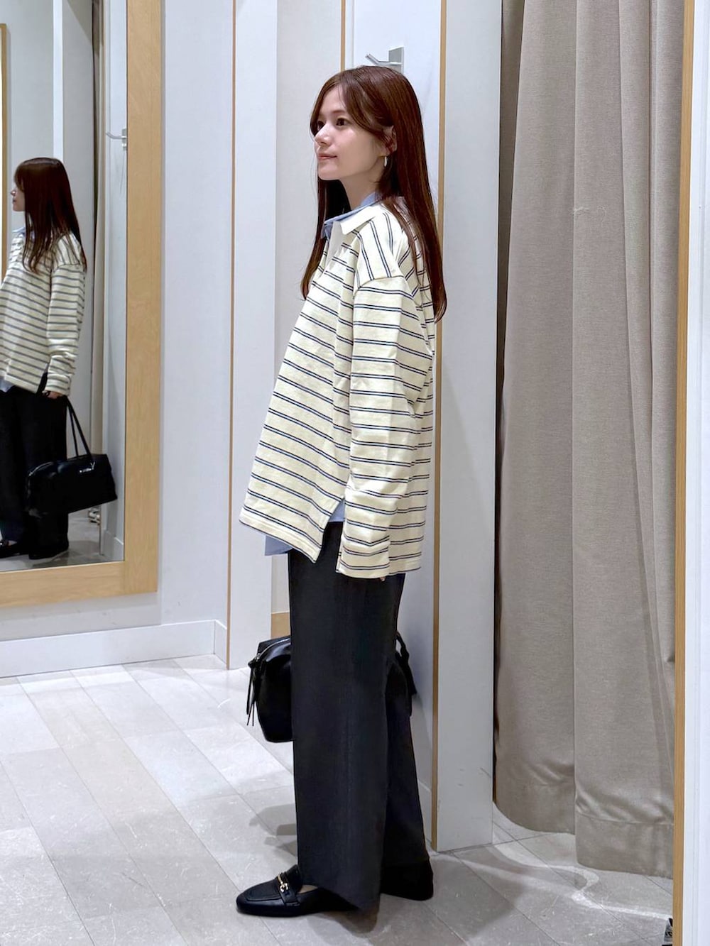 ブラック系のローファー、ブラック系のボストンバッグ、ブルー系のシャツ/ブラウスを着用したレディースの春コーディネートの2枚目の写真