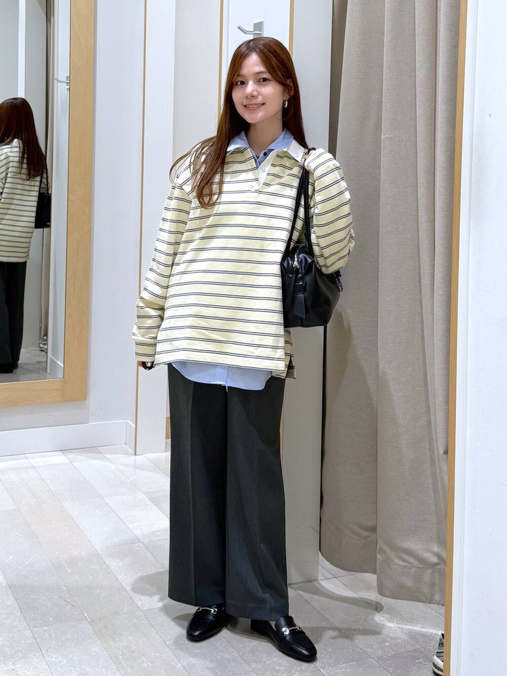 ブラック系のローファー、ブラック系のボストンバッグ、ブルー系のシャツ/ブラウスを着用したレディースの春コーディネートの4枚目の写真