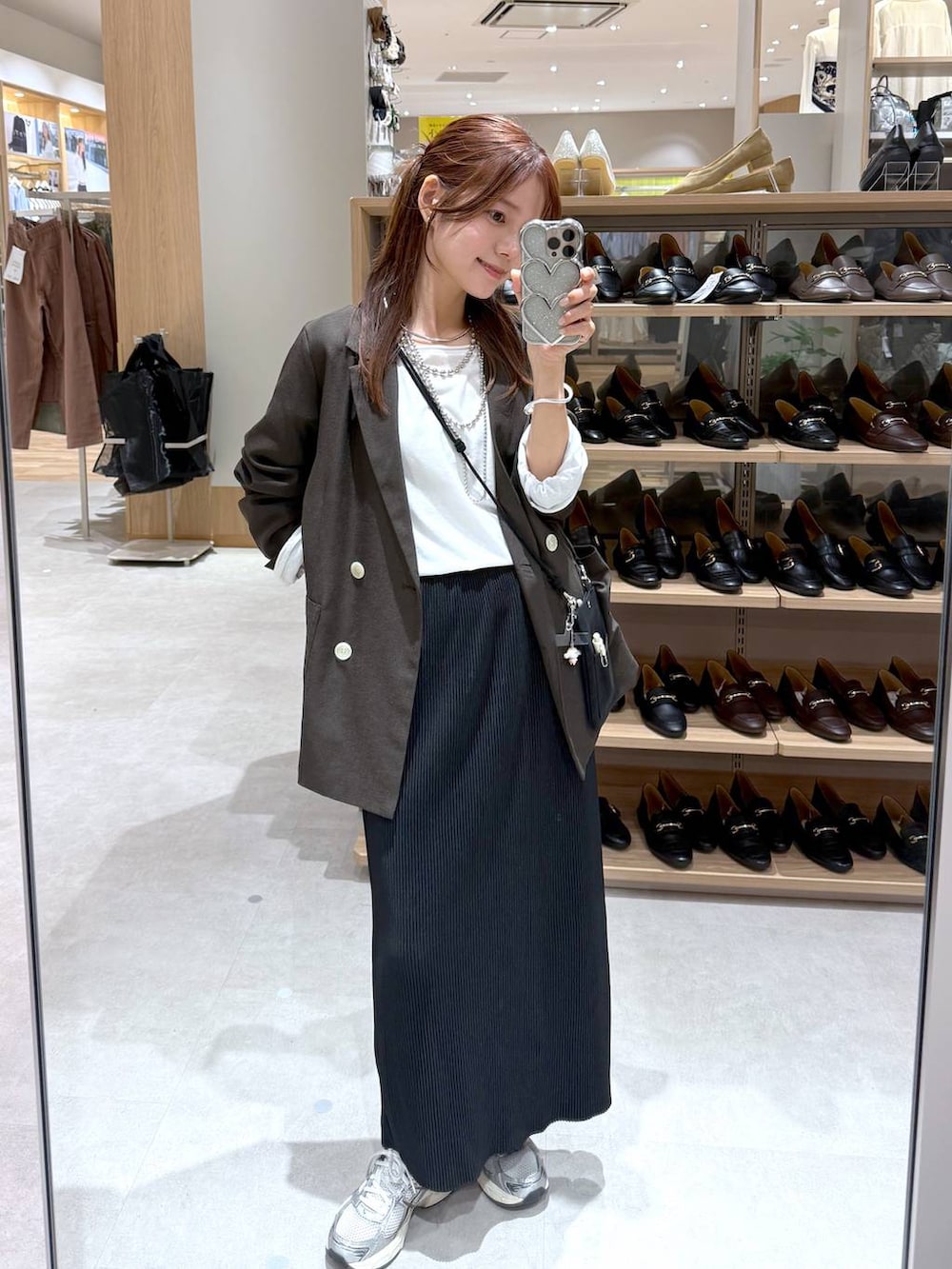 ブラック系のスカート、ブラウン系のテーラードジャケット、ホワイト系のTシャツ/カットソーを着用したレディースの秋コーディネートの4枚目の写真