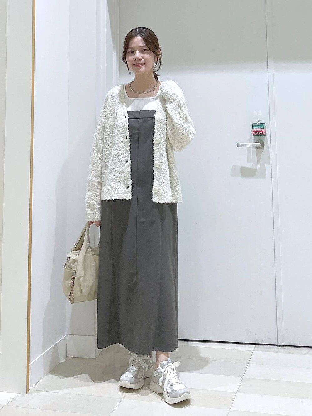 ブルー系のデニムパンツ、ブラック系のパンプス、ブラック系のショルダーバッグを着用したレディースの春コーディネートの6枚目の写真