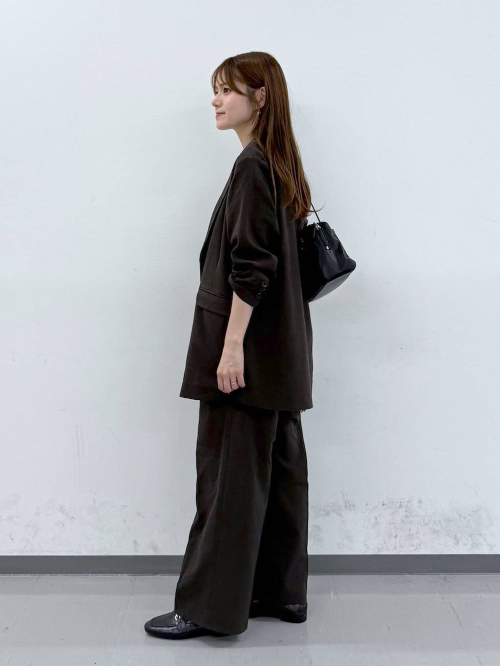 ブラック系のローファー、ブラック系のニット/セーター、ブラウン系のその他パンツを着用したレディースの春コーディネートの2枚目の写真