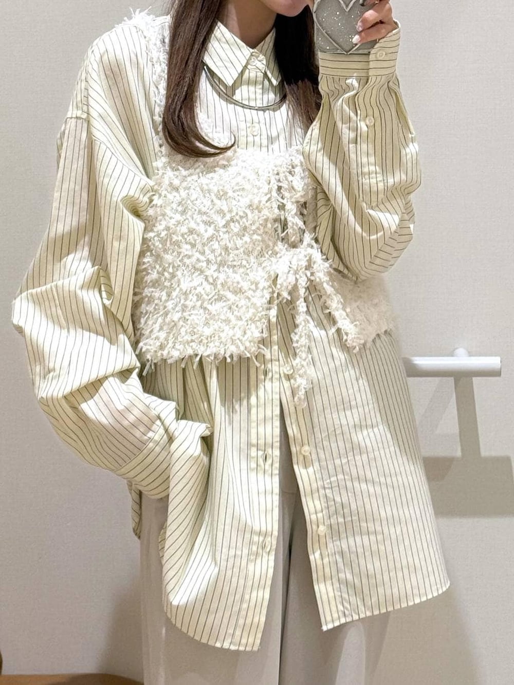 イエロー系のシャツ/ブラウス、ベージュ系のその他パンツ、ホワイト系のベストを着用したレディースの春コーディネートの3枚目の写真