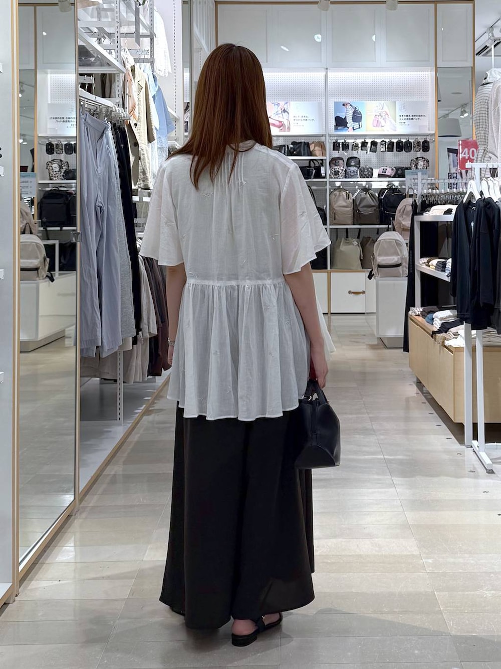 ブラック系のショルダーバッグ、イエロー系のタンクトップ、ブラウン系のその他パンツを着用したレディースの夏コーディネートの3枚目の写真