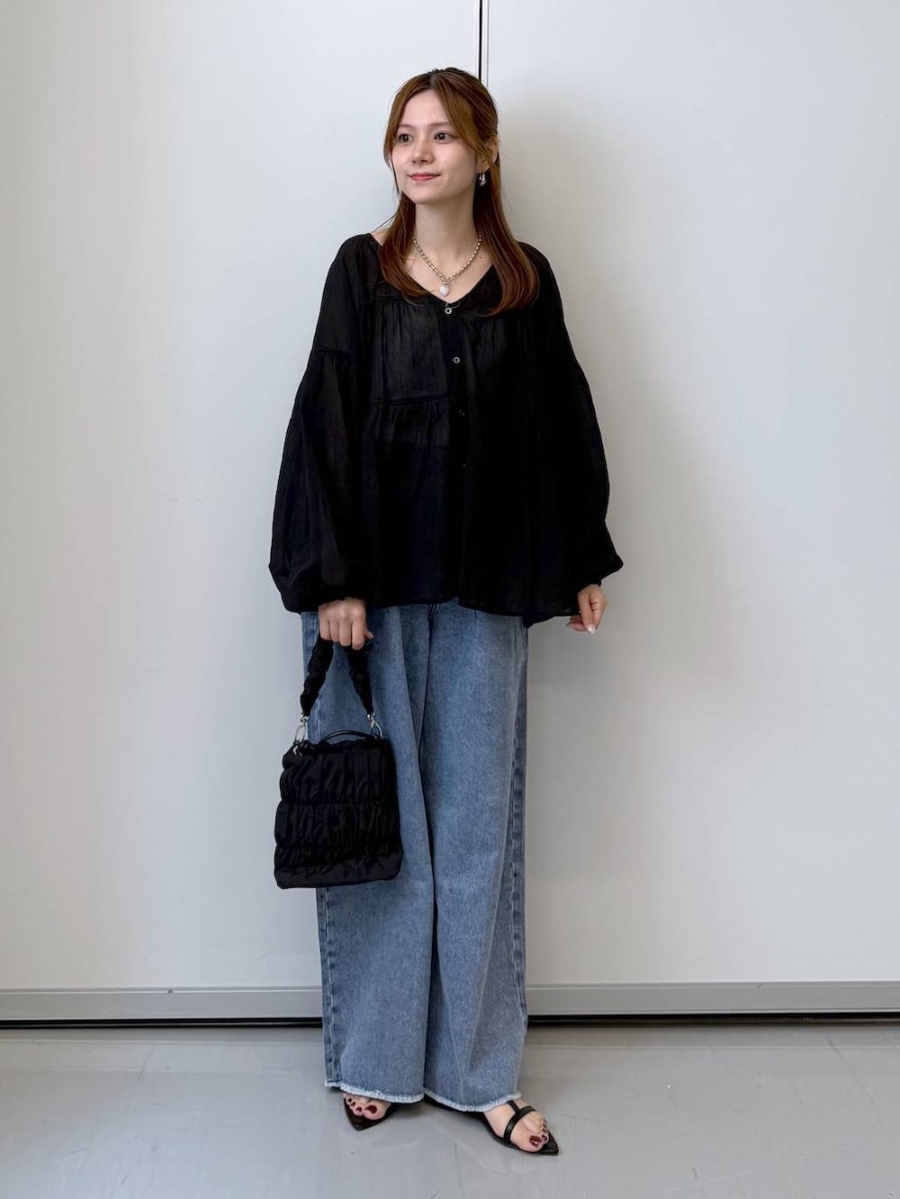 ブラック系のボディバッグ/ウエストポーチ、ブラック系のサンダル、ホワイト系のTシャツ/カットソーを着用したレディースの夏コーディネートの5枚目の写真