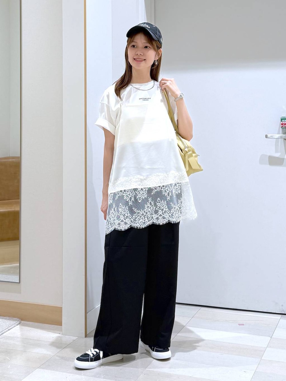 イエロー系のボストンバッグ、ブラック系のその他パンツ、ホワイト系のTシャツ/カットソーを着用したレディースの夏コーディネートの4枚目の写真