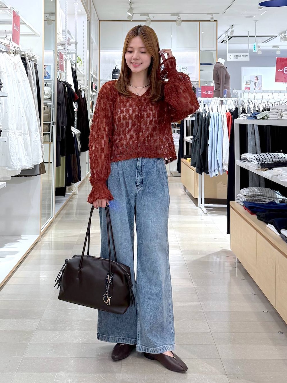 ブラウン系のパンプス、レッド系のカーディガン/ボレロ、ブラウン系のボストンバッグを着用したレディースの秋コーディネートの4枚目の写真