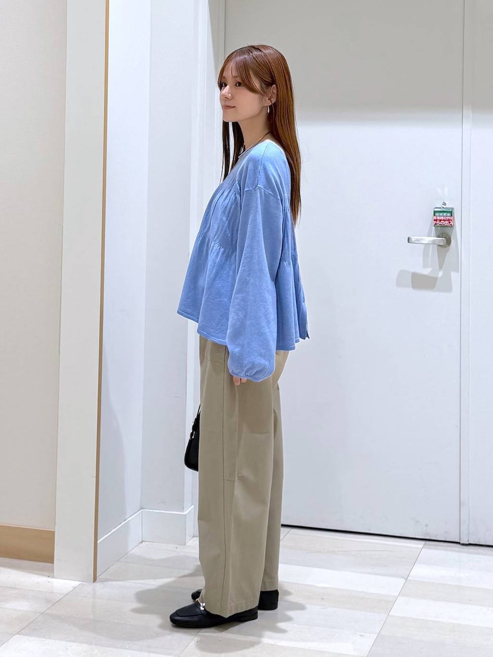 ブラック系のローファー、ブラック系のトートバッグ、ブルー系のカーディガン/ボレロを着用したレディースの春コーディネートの2枚目の写真