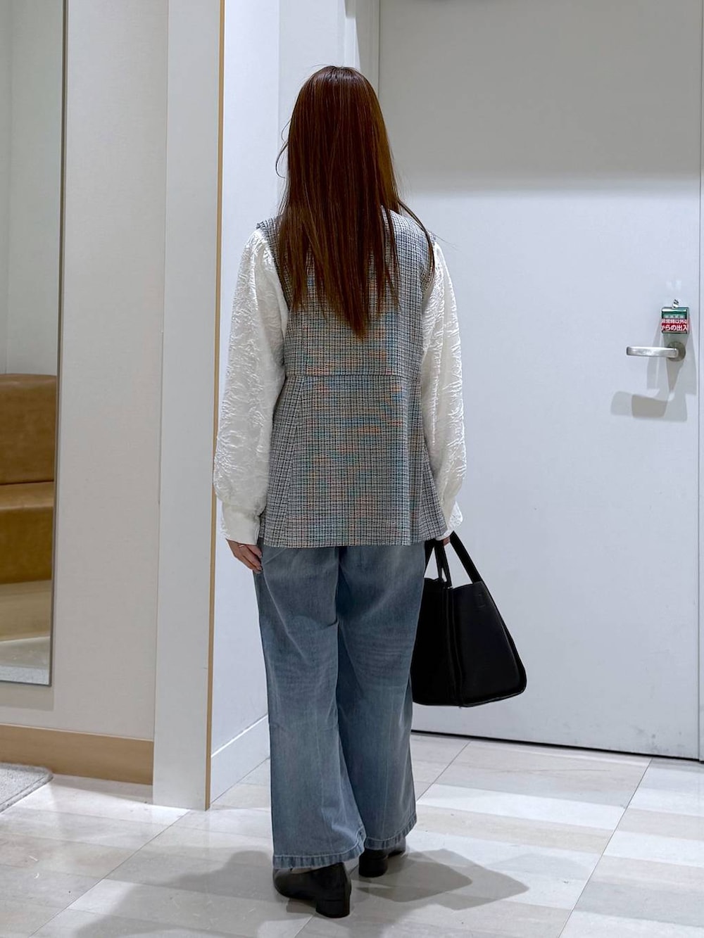 ブルー系のデニムパンツ、ブラック系のパンプス、ブラック系のトートバッグを着用したレディースの春コーディネートの3枚目の写真