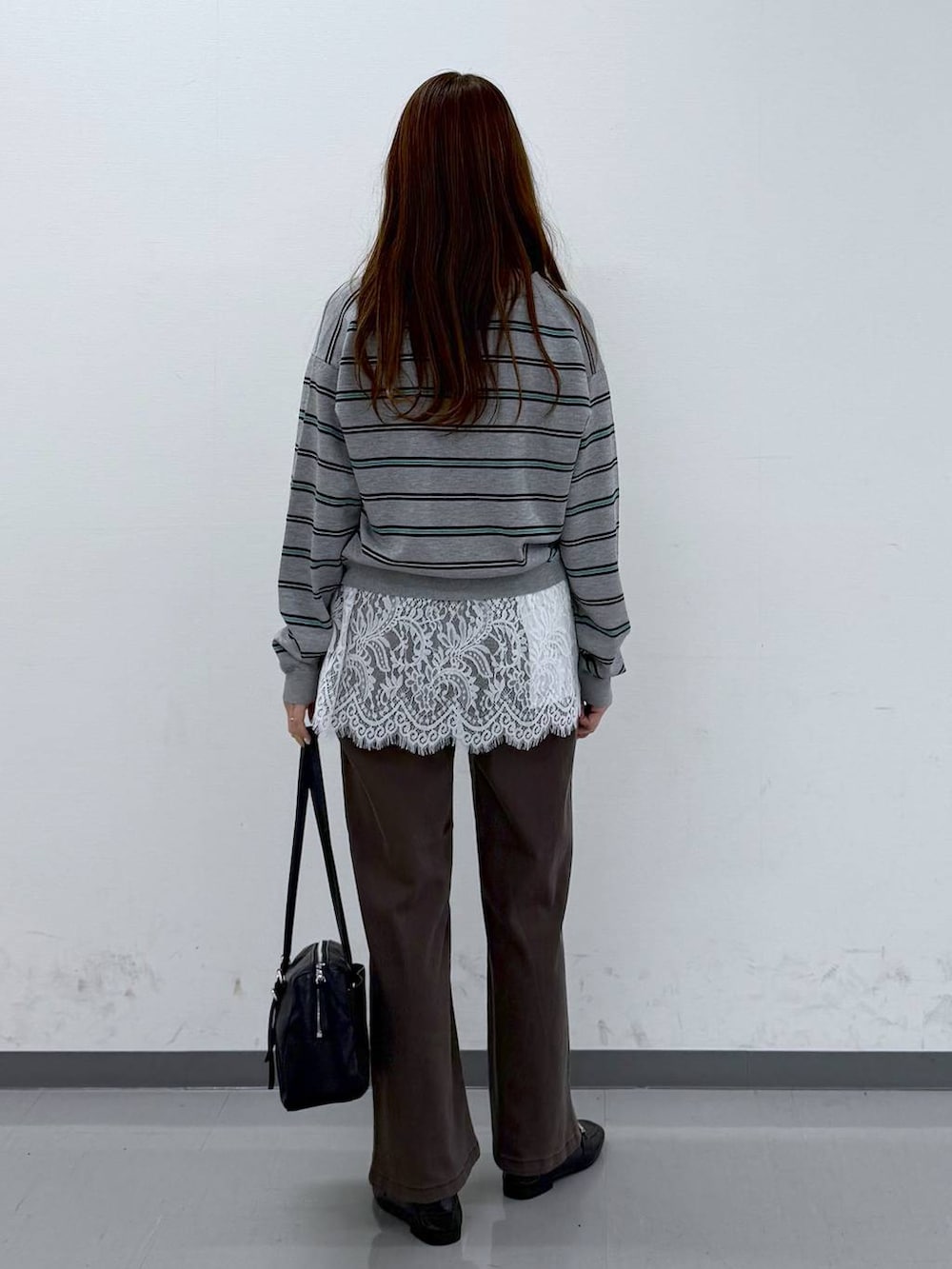 ブラック系のローファー、ブラウン系のデニムパンツ、ホワイト系のタンクトップを着用したレディースの春コーディネートの2枚目の写真