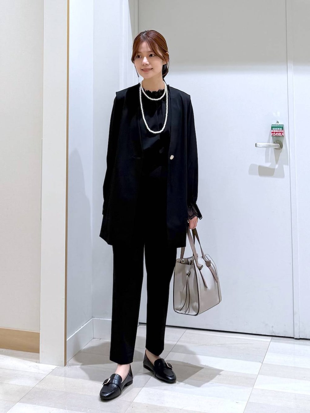 ブラック系のローファー、ホワイト系のショルダーバッグ、ブラック系のシャツ/ブラウスを着用したレディースの冬コーディネートの4枚目の写真