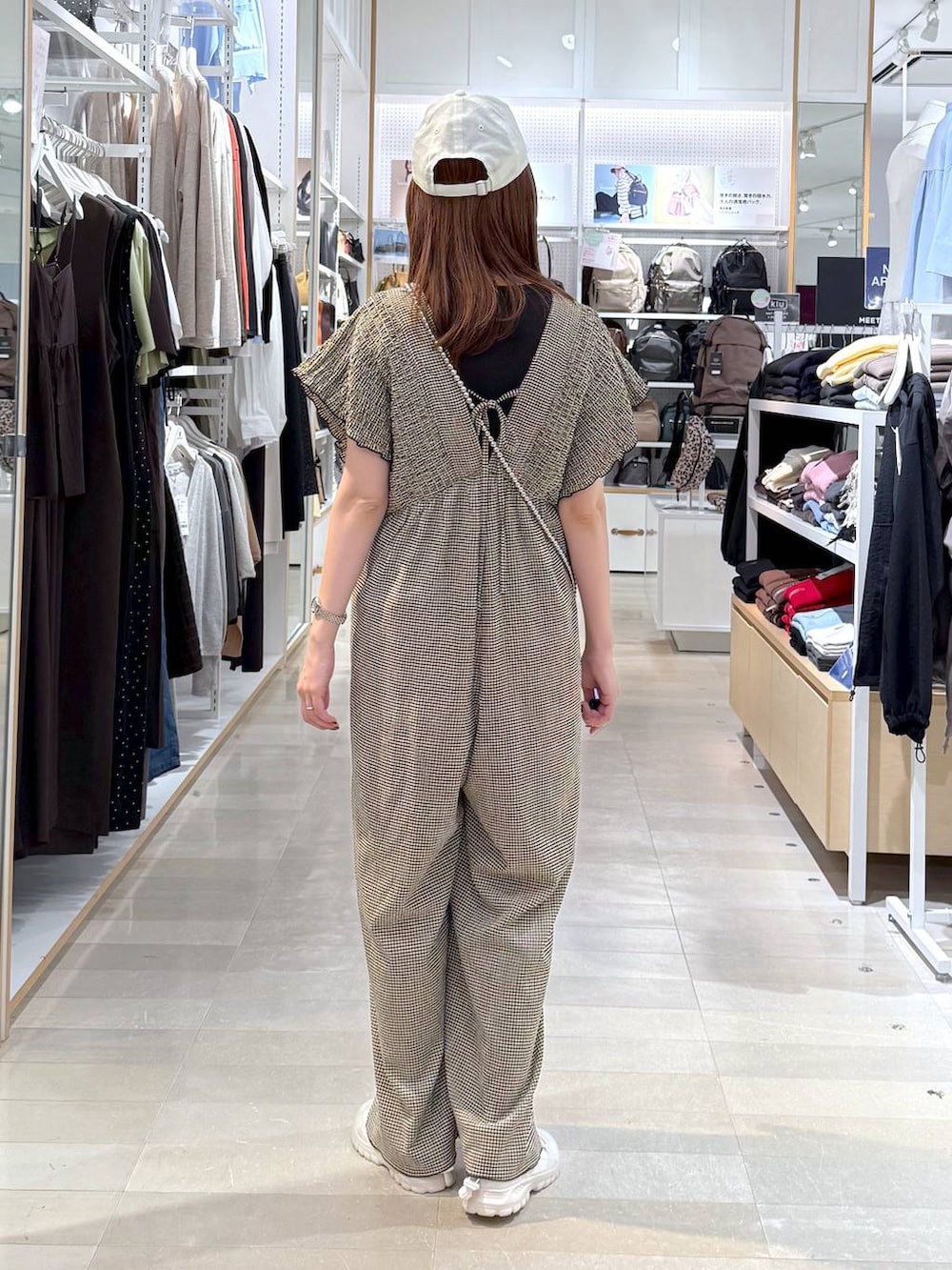 ホワイト系のスニーカー、ブラウン系のTシャツ/カットソー、イエロー系のサロペット/オーバーオールを着用したレディースの春コーディネートの3枚目の写真