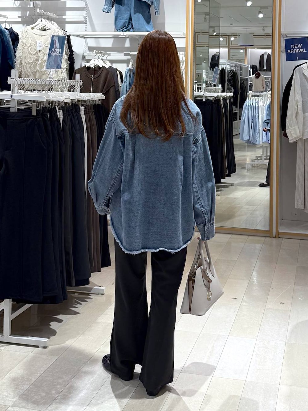 ブラック系のバレエシューズ、ホワイト系のショルダーバッグ、ブルー系のシャツ/ブラウスを着用したレディースの春コーディネートの3枚目の写真