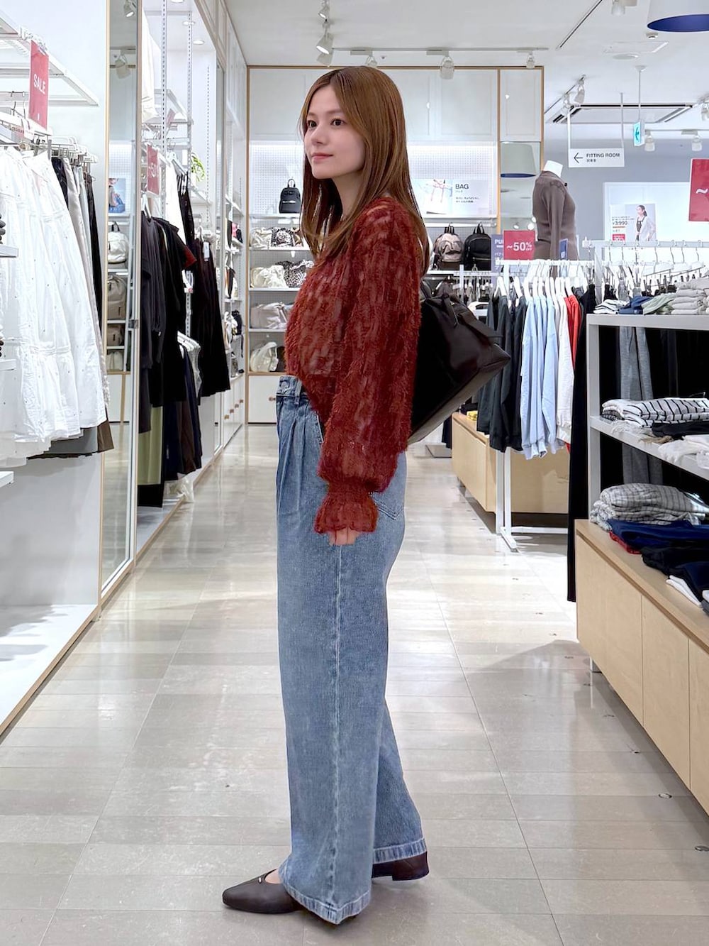 ブラウン系のパンプス、レッド系のカーディガン/ボレロ、ブラウン系のボストンバッグを着用したレディースの秋コーディネートの2枚目の写真