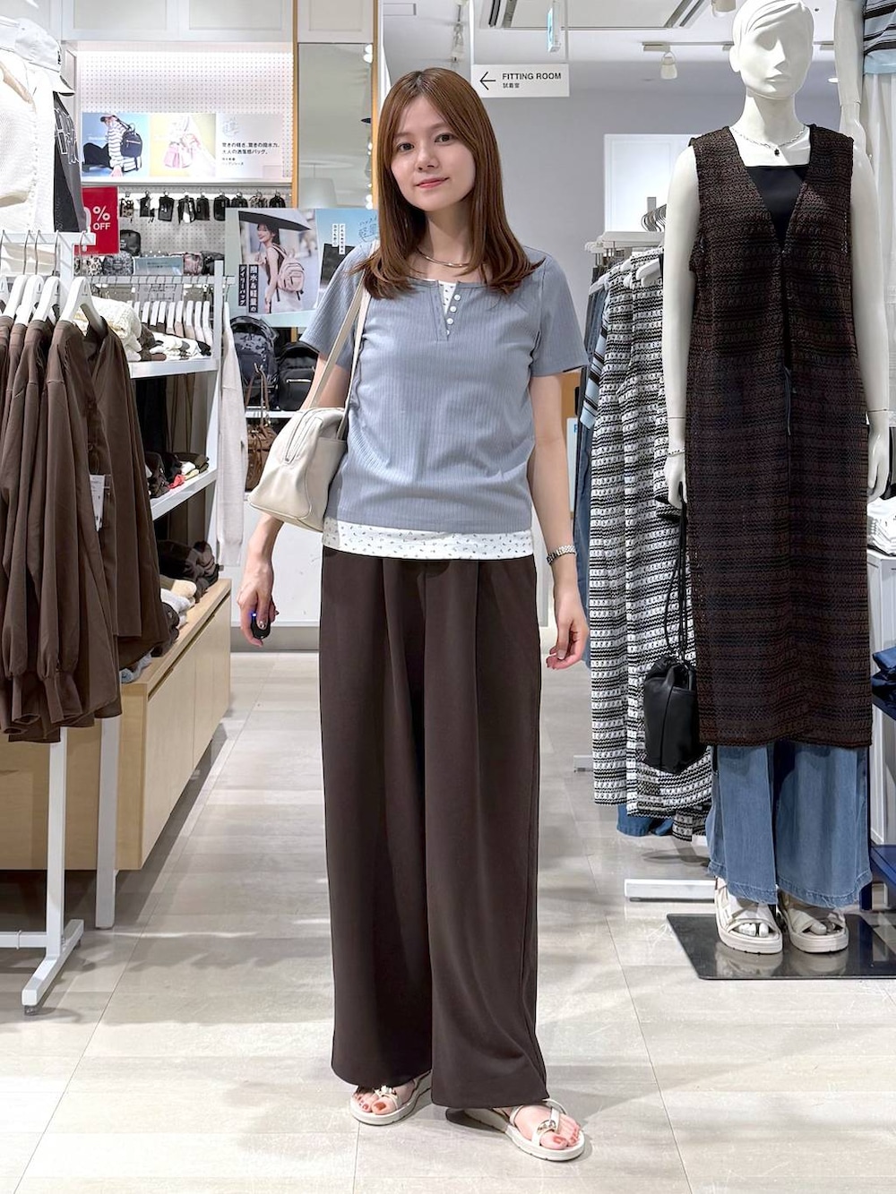 ベージュ系のショルダーバッグ、ブラウン系のその他パンツ、ブルー系のTシャツ/カットソーを着用したレディースの夏コーディネートの4枚目の写真