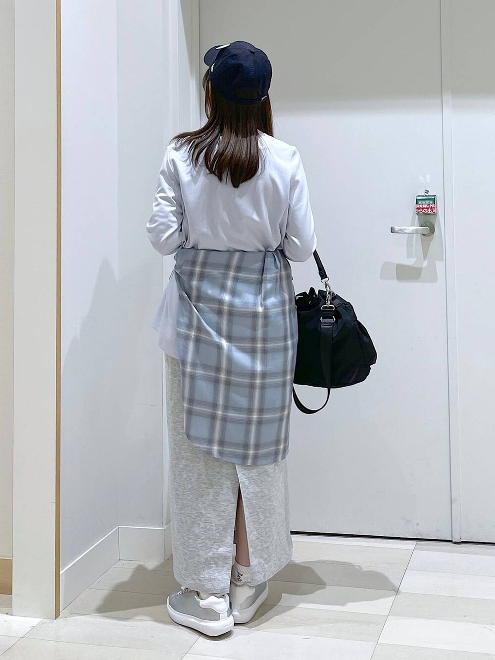 シルバー系のスニーカー、ブラック系のショルダーバッグ、ブルー系のシャツ/ブラウスを着用したレディースの春コーディネートの3枚目の写真