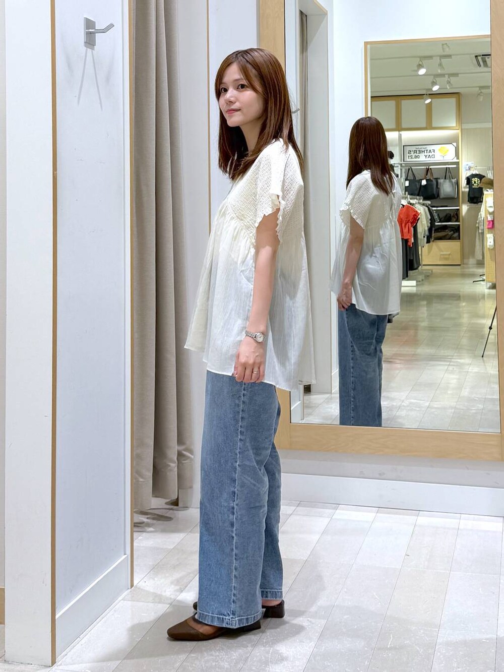 ブルー系のデニムパンツ、ホワイト系のタンクトップ、ベージュ系のシャツ/ブラウスを着用したレディースの夏コーディネートの2枚目の写真