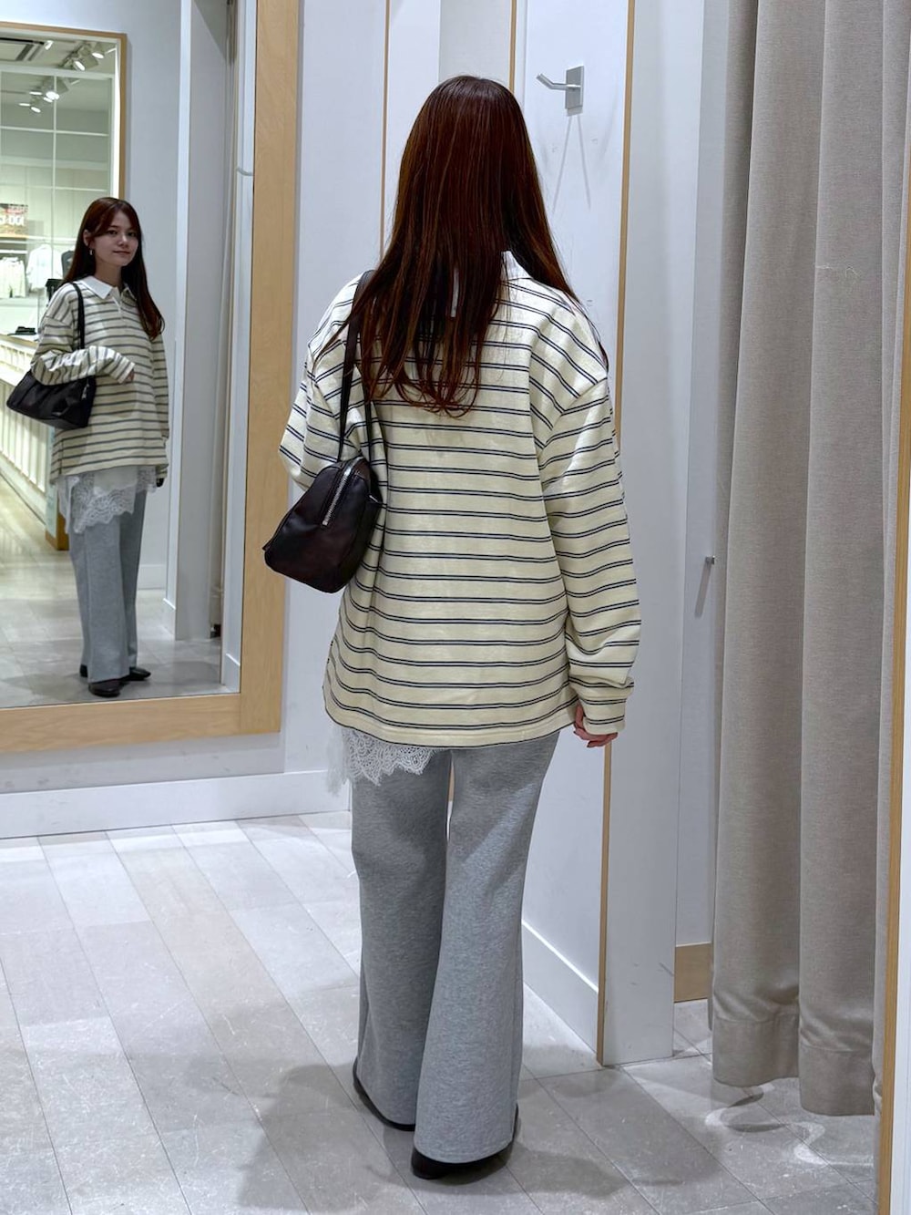 グレー系のスウェットパンツ、イエロー系のスウェット、ブラウン系のショルダーバッグを着用したレディースの春コーディネートの3枚目の写真