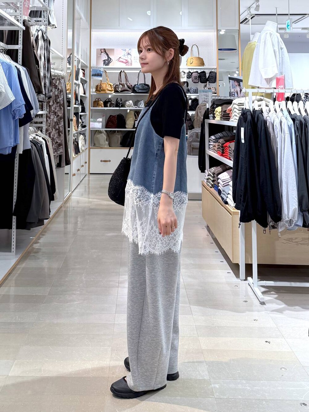 グレー系のスニーカー、グレー系のその他パンツ、ブラック系のクラッチバッグを着用したレディースの春コーディネートの2枚目の写真