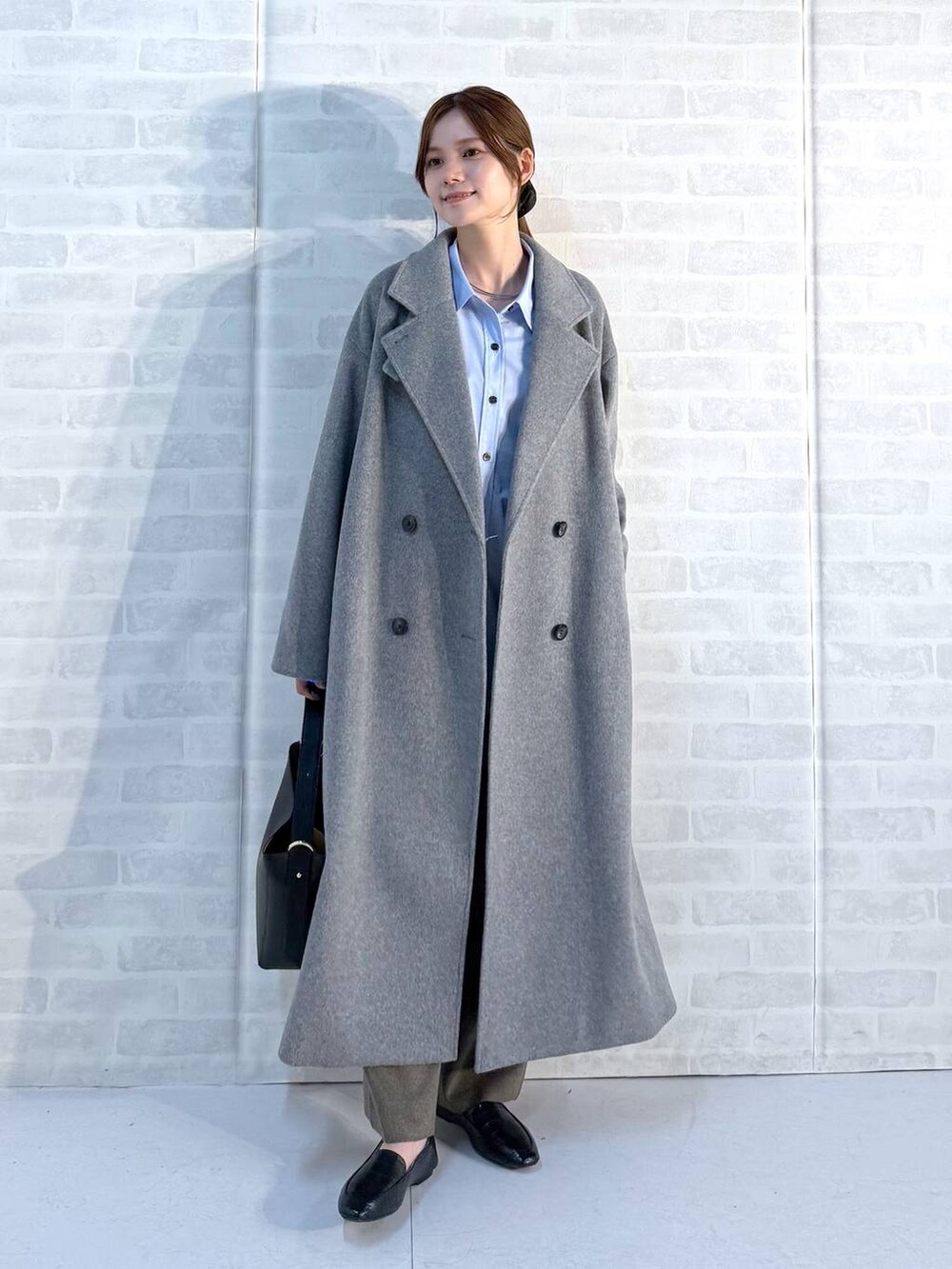 ブラック系のその他シューズ、ブラック系のショルダーバッグ、ブルー系のシャツ/ブラウスを着用したレディースの秋コーディネートの4枚目の写真