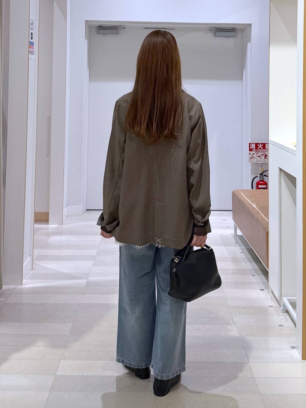 ブラック系のローファー、ブラック系のショルダーバッグ、ブルー系のデニムパンツを着用したレディースの春コーディネートの3枚目の写真