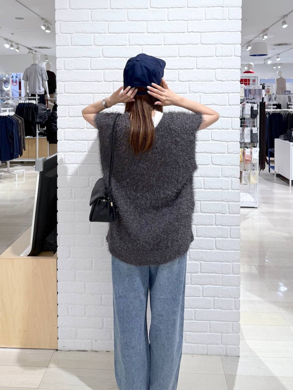 ブルー系のデニムパンツ、ホワイト系のTシャツ/カットソー、ブラック系のショルダーバッグを着用したレディースの秋コーディネートの4枚目の写真