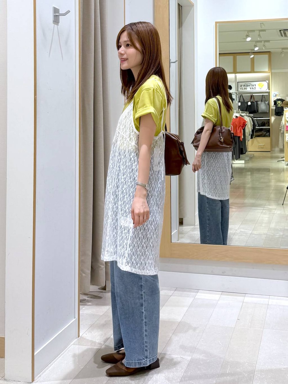 ブラウン系のボストンバッグ、ブルー系のデニムパンツ、イエロー系のTシャツ/カットソーを着用したレディースの夏コーディネートの2枚目の写真