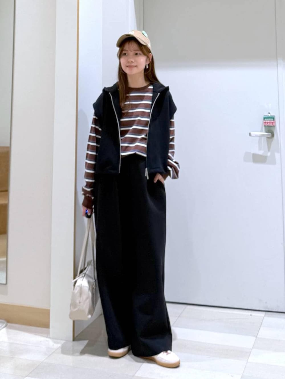 ホワイト系のボストンバッグ、ブラック系のスウェットパンツ、ブラウン系のTシャツ/カットソーを着用したレディースの冬コーディネートの4枚目の写真