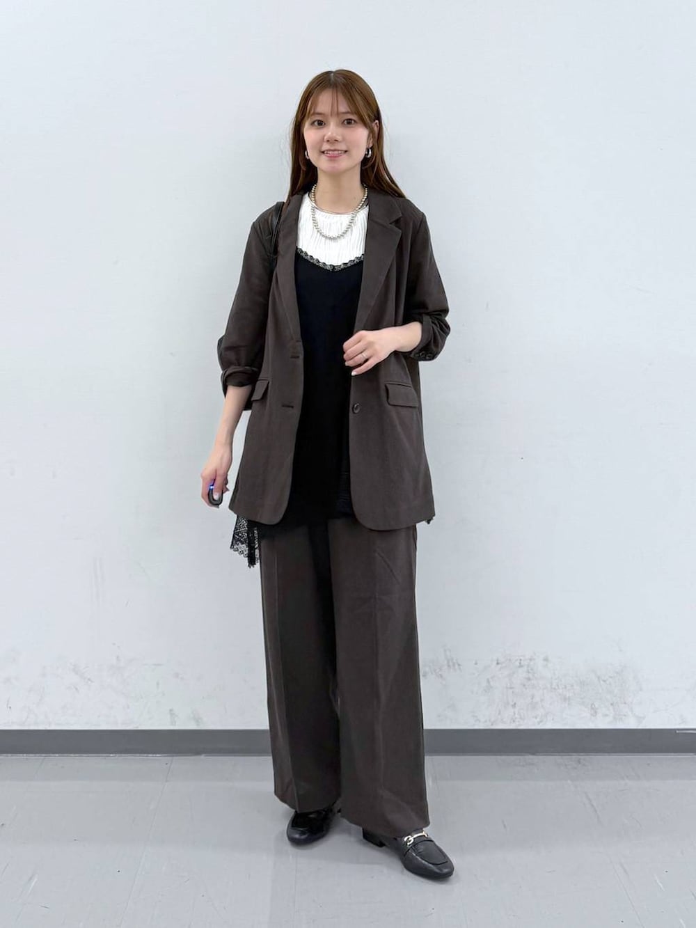 ブラック系のローファー、ブラック系のニット/セーター、ブラウン系のその他パンツを着用したレディースの春コーディネートの5枚目の写真