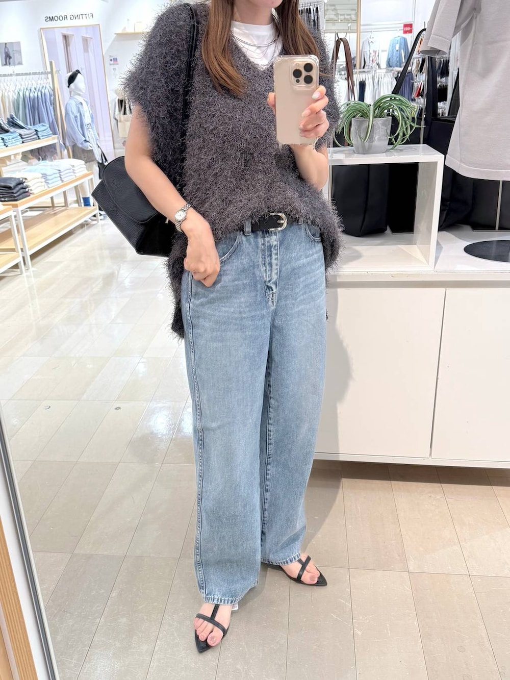 ブルー系のデニムパンツ、ホワイト系のTシャツ/カットソー、ブラック系のショルダーバッグを着用したレディースの秋コーディネートの6枚目の写真