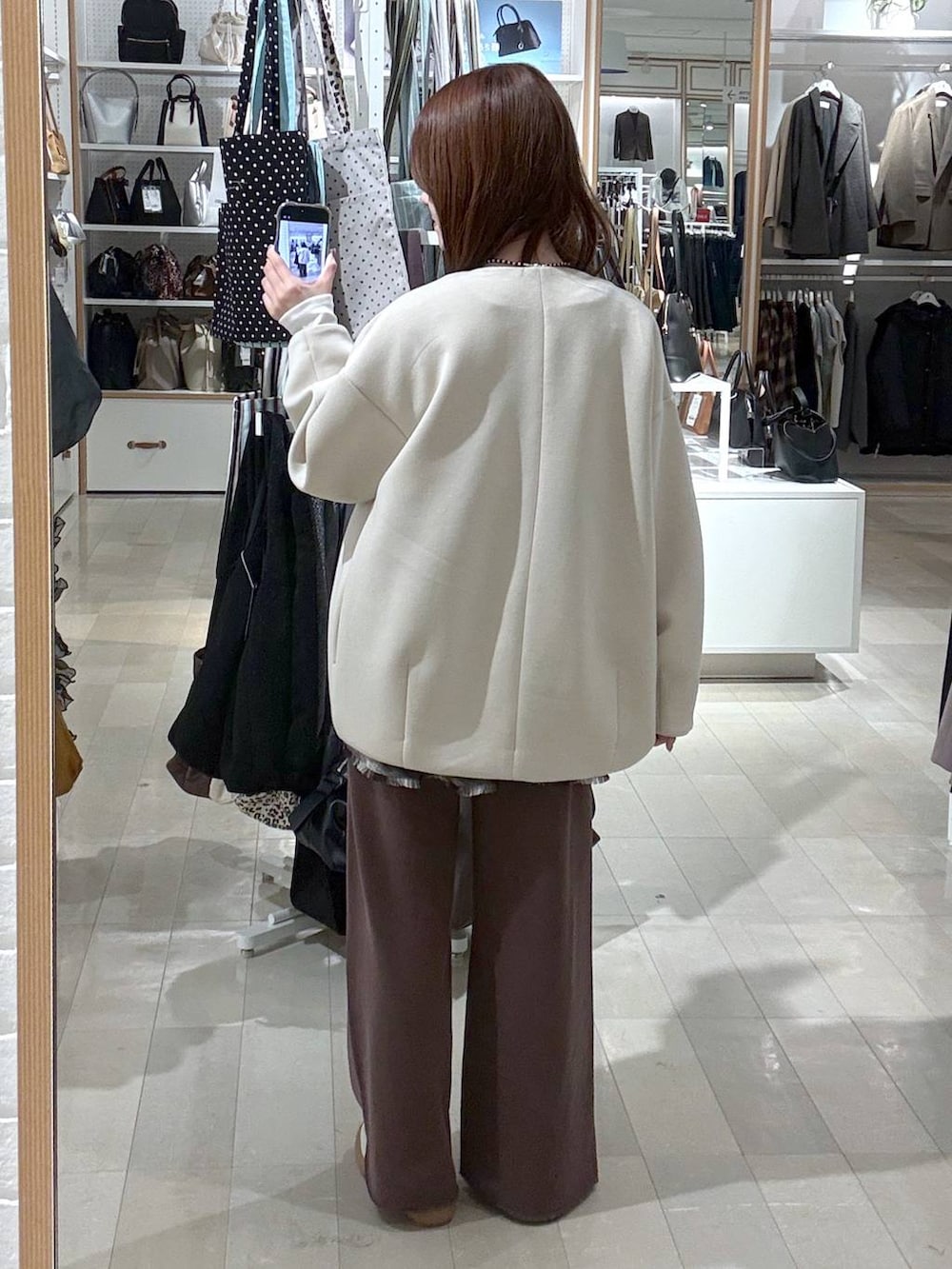 ホワイト系のスニーカー、ホワイト系のブルゾン、ブラウン系のその他トップスを着用したレディースの冬コーディネートの3枚目の写真