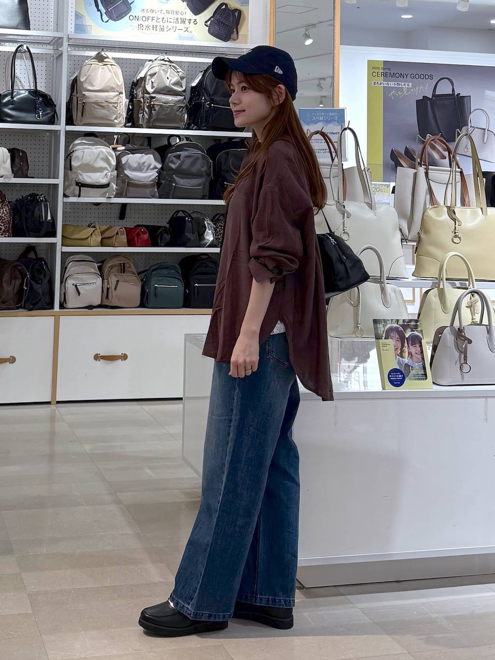 ブラック系のローファー、ブルー系のデニムパンツ、ブラック系のショルダーバッグを着用したレディースの春コーディネートの2枚目の写真