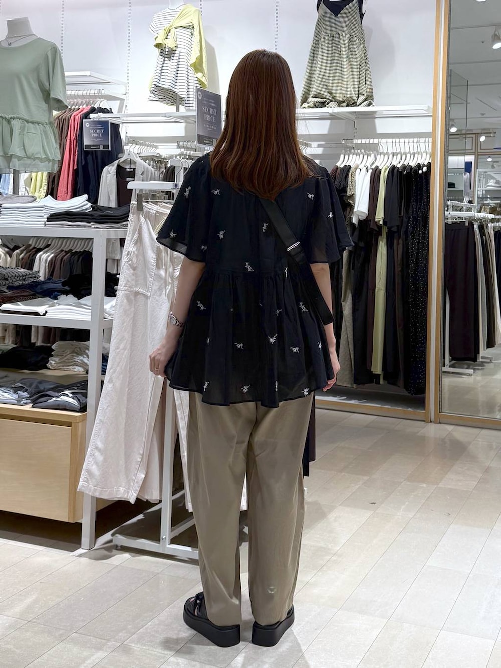 ホワイト系のタンクトップ、ベージュ系のその他パンツ、ブラック系のショルダーバッグを着用したレディースの夏コーディネートの3枚目の写真