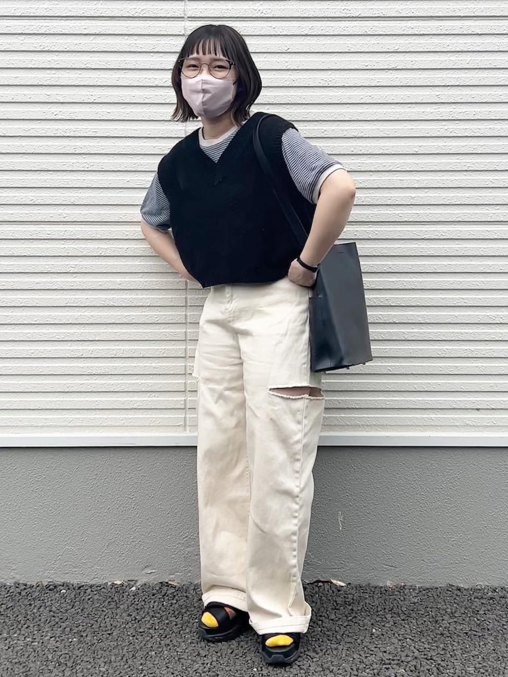 ブラック系のトートバッグ、ブラック系のベスト、ホワイト系のデニムパンツを着用したレディースの夏コーディネートの2枚目の写真