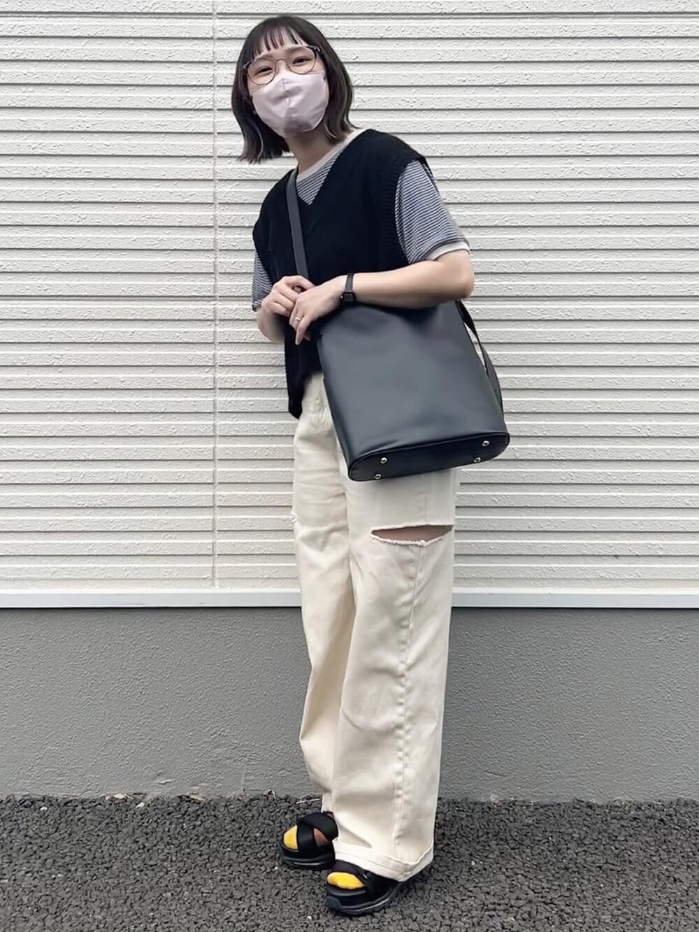 ブラック系のトートバッグ、ブラック系のベスト、ホワイト系のデニムパンツを着用したレディースの夏コーディネートの4枚目の写真