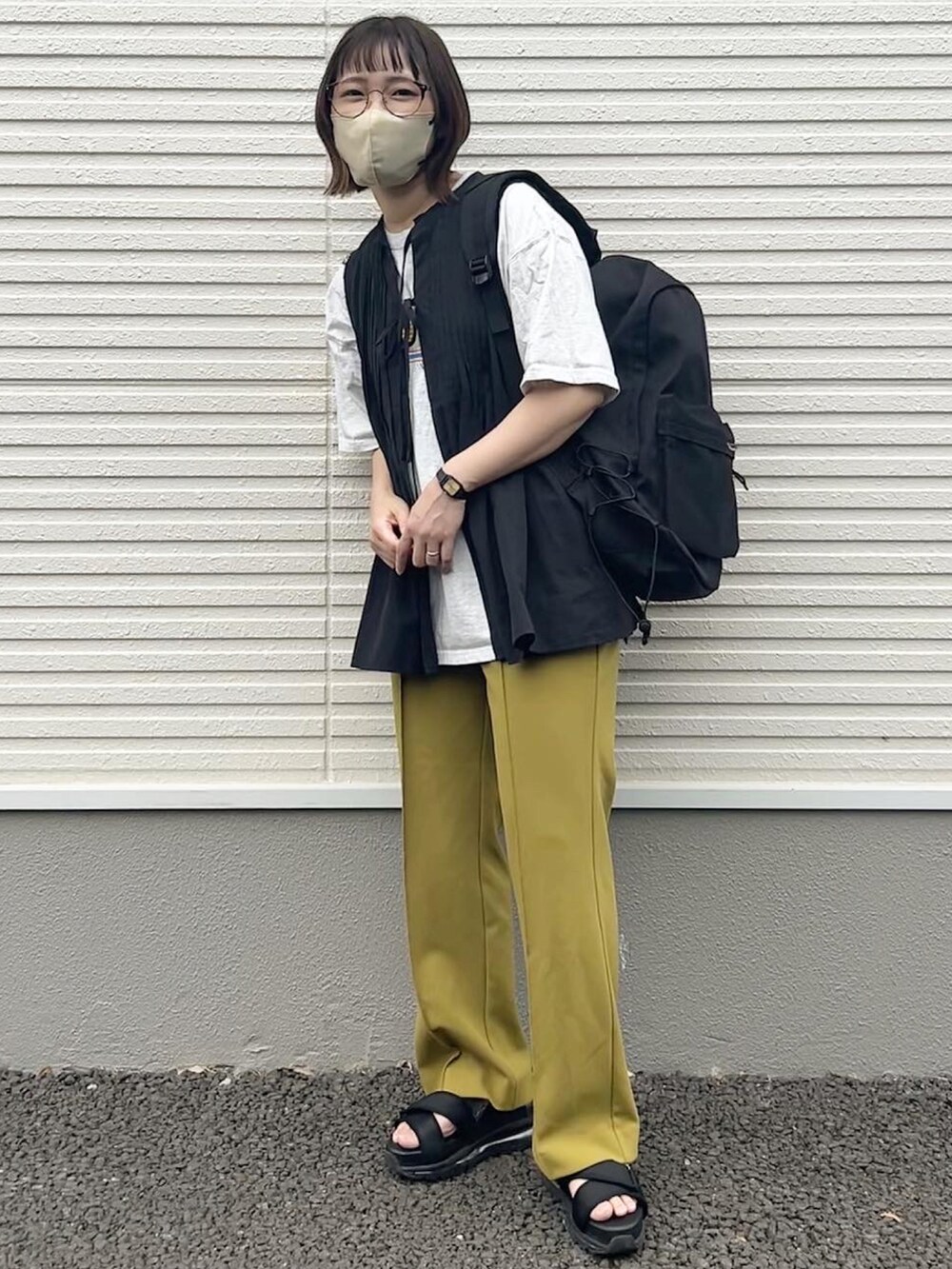 ブラック系のサンダル、イエロー系のその他パンツ、ブラック系のベストを着用したレディースの夏コーディネートの2枚目の写真