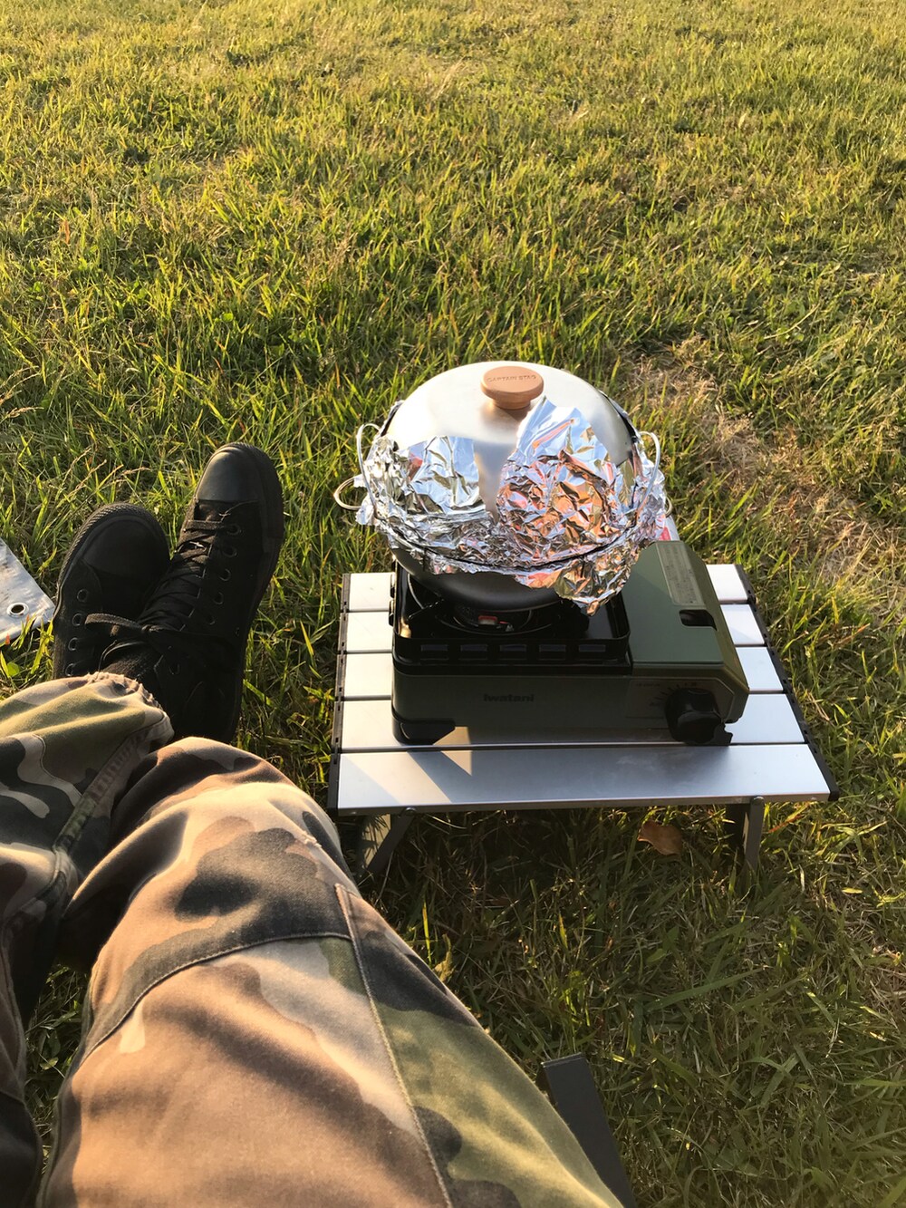 グリーン系のカーゴパンツ、ブラック系のスニーカー、ブラック系のパーカーを着用したメンズの春コーディネートの2枚目の写真