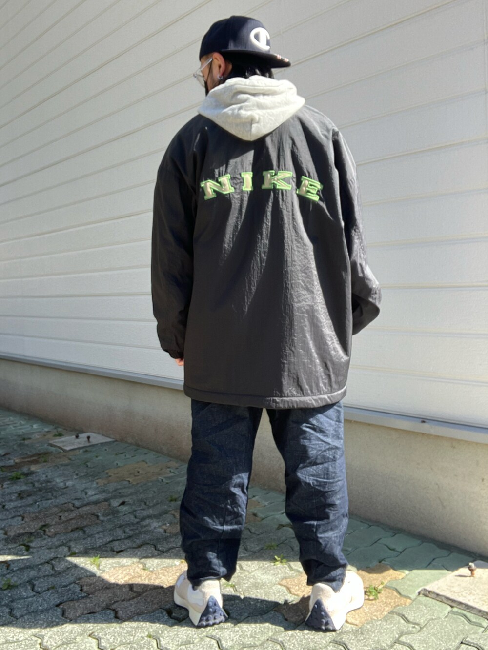 ブラック系のジャケット/アウター、グレー系のパーカー、ホワイト系のスニーカーを着用したメンズの冬コーディネートの2枚目の写真