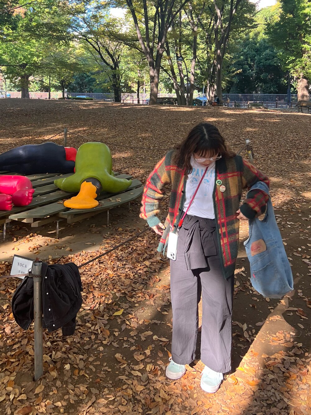 グリーン系のカーディガン/ボレロ、ホワイト系のTシャツ/カットソー、ブラック系のつなぎ/オールインワンを着用したレディースの秋コーディネートの3枚目の写真